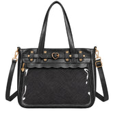 Black ita bag with a textured woven front panel, glossy clear front pocket, gold-tone heart and star hardware, and a detachable shoulder strap on a white background.
