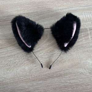 Black cat ears faux fur on a wooden surface