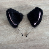 Black cat ears faux fur on a wooden surface