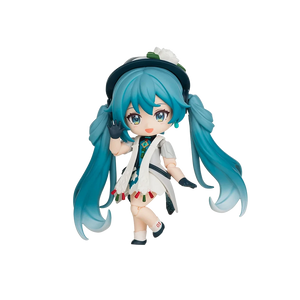 A chibi-style vinyl figure of Hatsune Miku with long teal-blue twin tails, wearing a white coat over a multicolored outfit, black gloves, and a dark hat with a white flower, isolated on a black background.