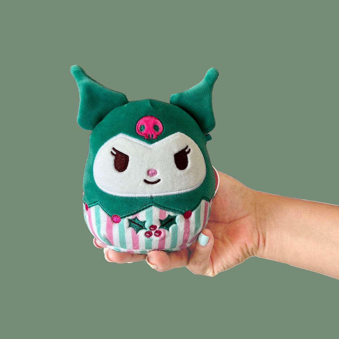 Kuromi Squishmallows Xmas Plush toy with green hood and striped body held in a hand against a green background