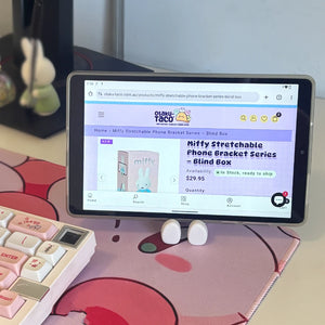 Pad displaying an online product listing on a desk with a keyboard and earbuds.