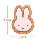 Cork coaster with a cartoon Miffy bunny face and measurements on a white background
