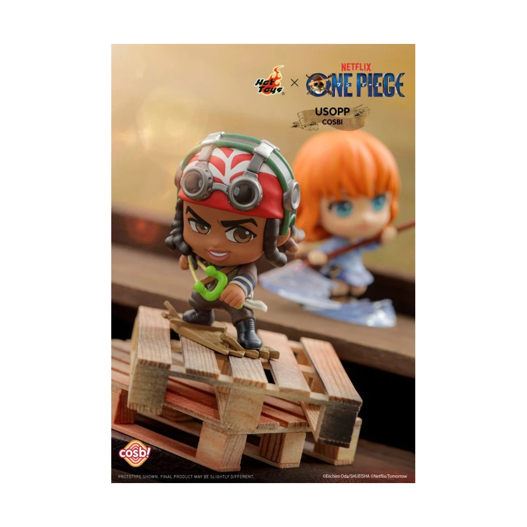 Hot Toys x Netflix One Piece USOPP Cosplay collectible figure of Usopp, shown in a stylized display with a wooden crate and a blurred background figure.