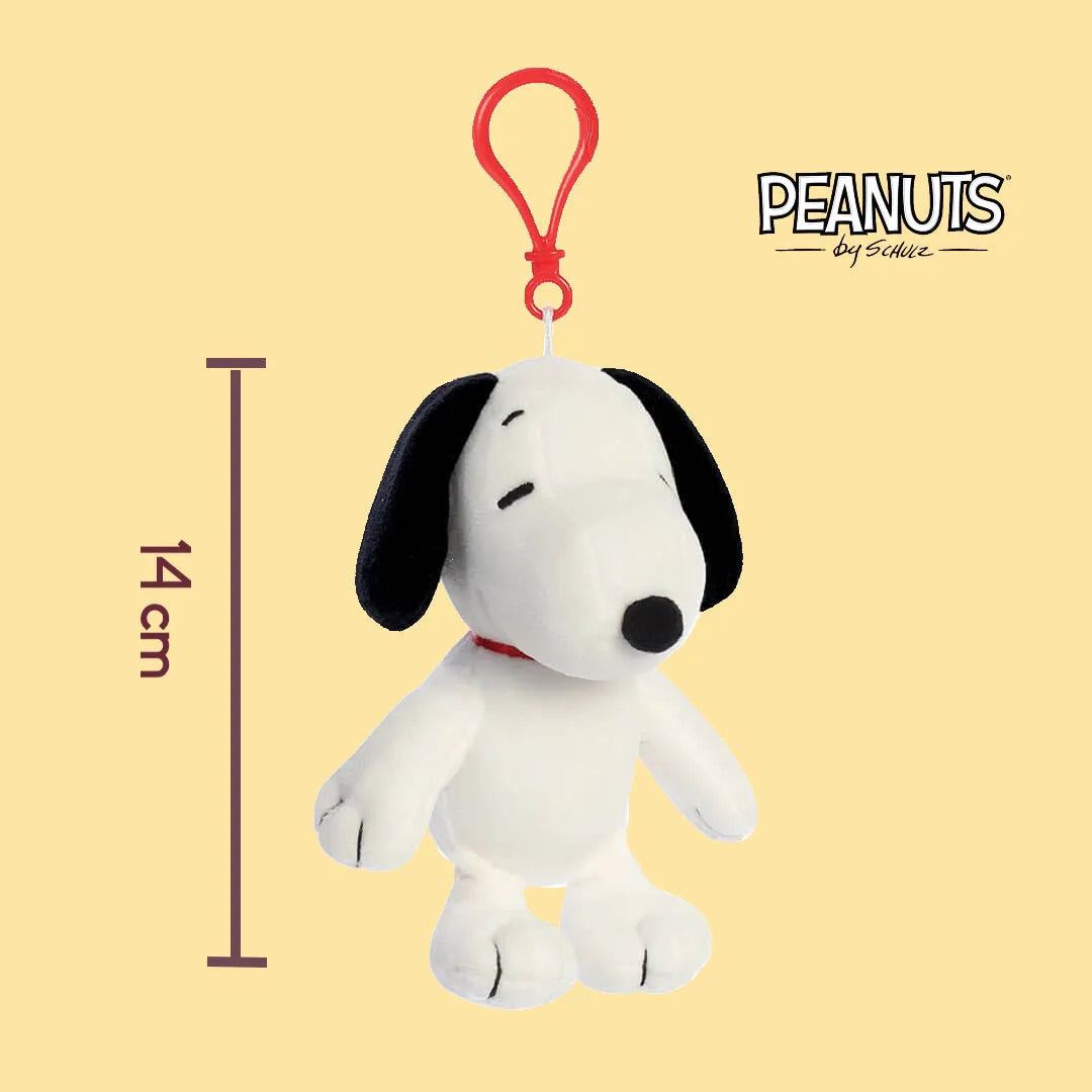 Plush keychain of Snoopy dog with a red tag on a yellow background, featuring the Peanuts logo.