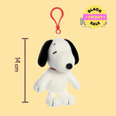 Plush keychain of Snoopy dog with a red tag on a yellow background, featuring the Peanuts logo.