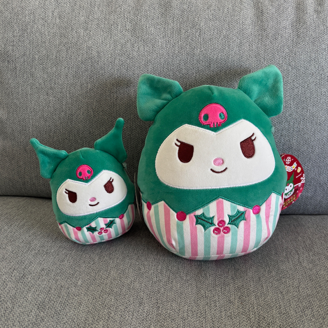 Two green Holiday plush toys of Kuromi  with striped patterns on a gray couch
