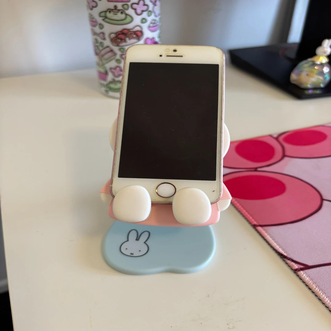 Phone stand with a smartphone on a desk, Miffy blind box stand use demonstration