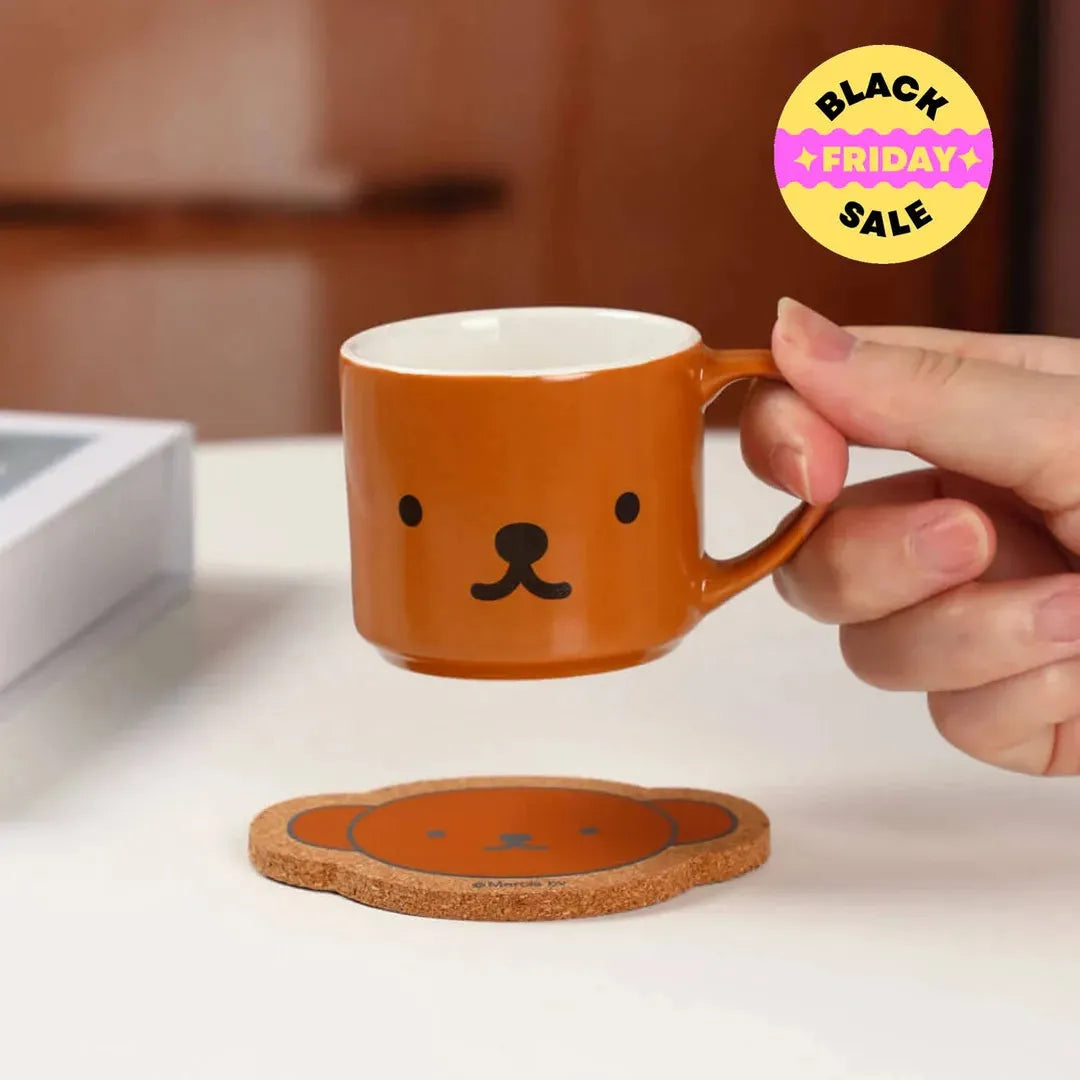 Person holding a brown mug with a bear face design . Miffy blind box