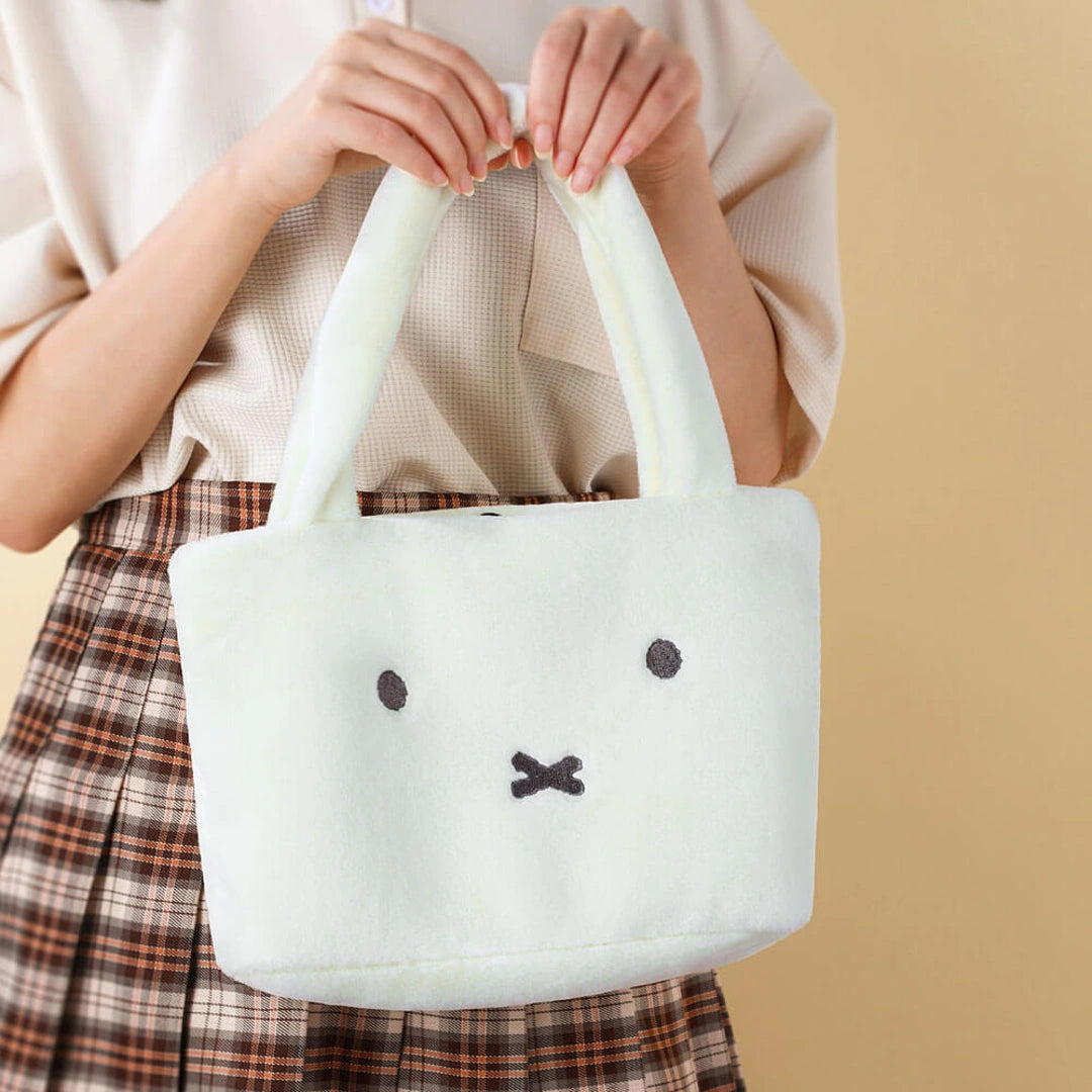 Person holding a white Miffy plush bag