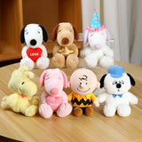 Set of small stuffed animals from Peanuts Snoopy on a wooden surface
