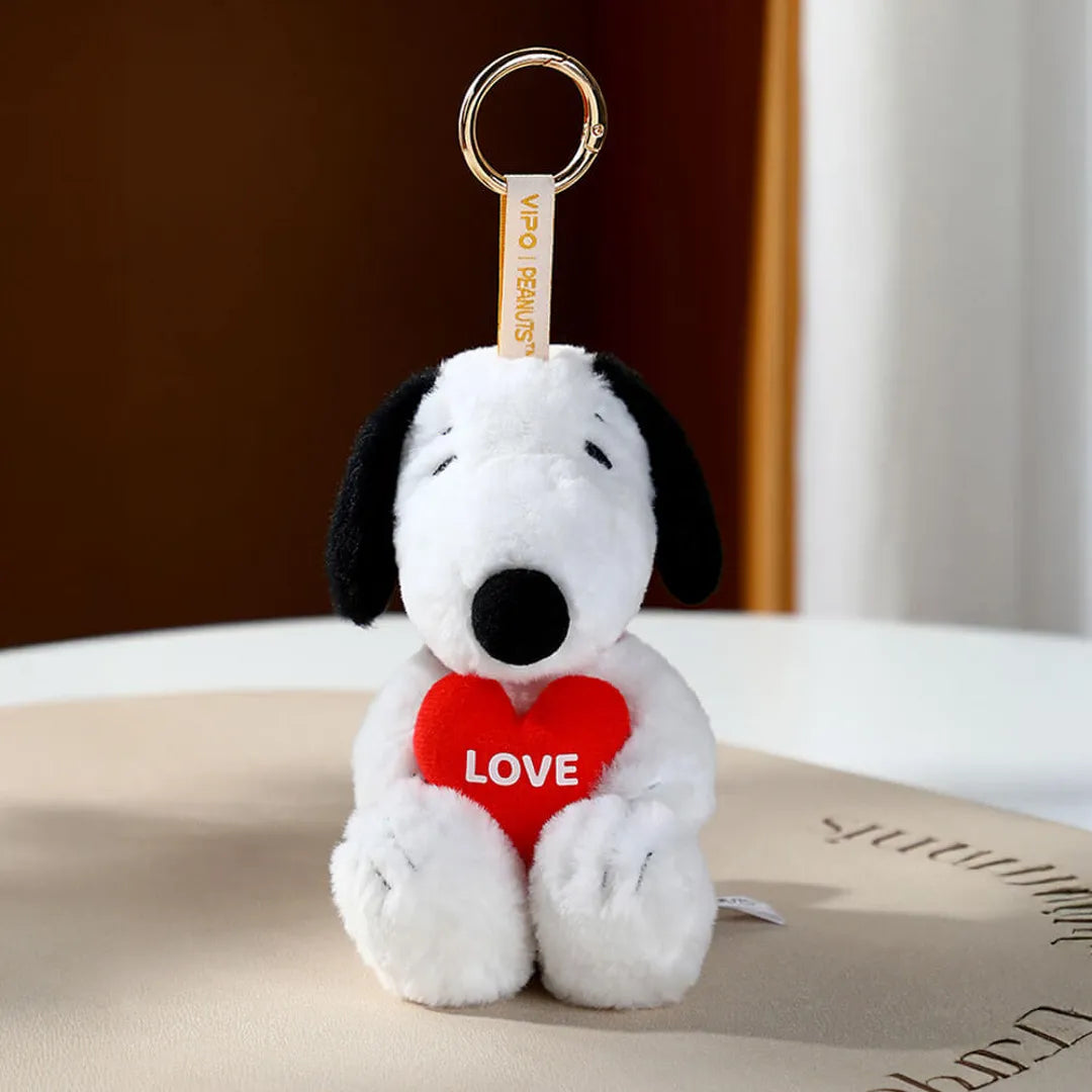 Snoopy Plush dog keychain with a red heart and 'LOVE' text on a surface.