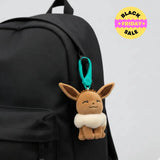Plush Eevee keychain attached to a black backpack. Pokemon bag clip