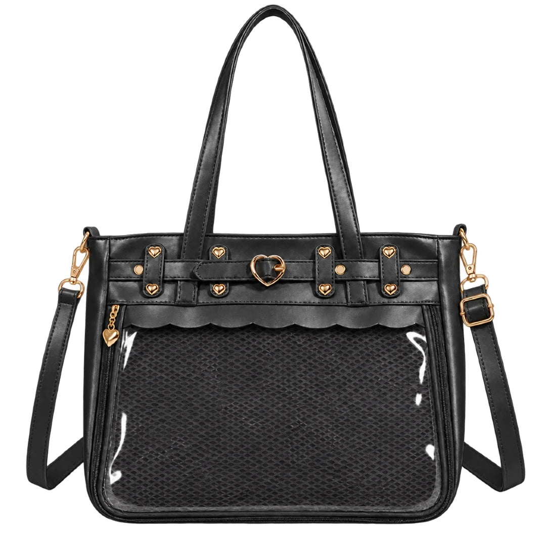 Black ita bag with a textured woven front panel, glossy clear front pocket, gold-tone heart and star hardware, and a detachable shoulder strap on a white background.