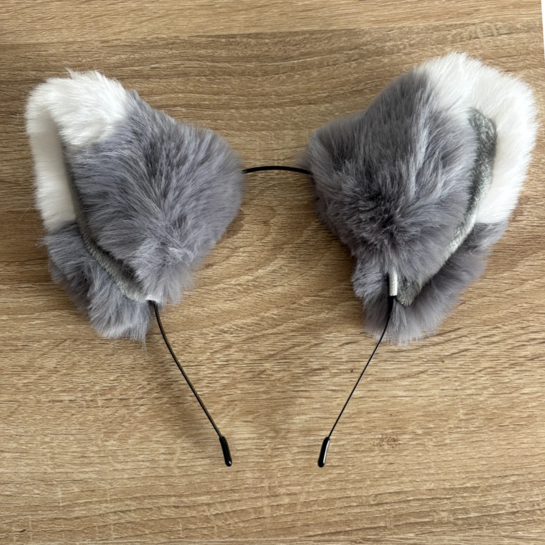 Gray and white faux fur cat ears headband on a light brown wooden surface.