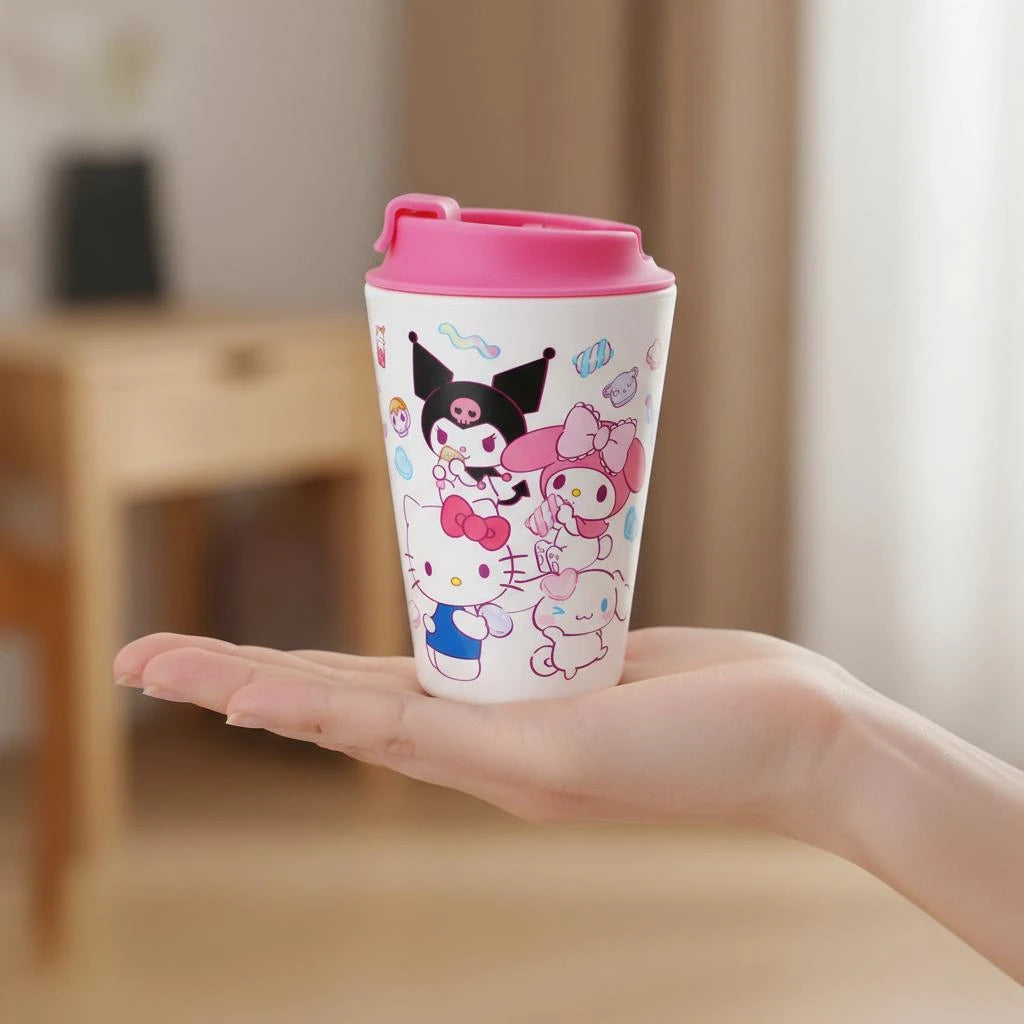 Person holding a Sanrio travel mug with a pink lid. Design includes Kuromi, Hello Kittty, My Melody and Cinnamorroll