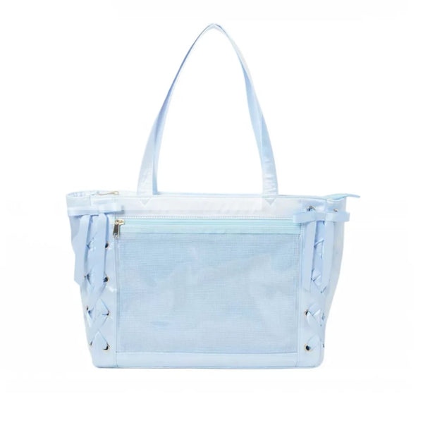 A light blue ita shoulder bag with a front mesh pocket, double shoulder straps, and decorative side lacing with metal grommets, shown against a plain white background.