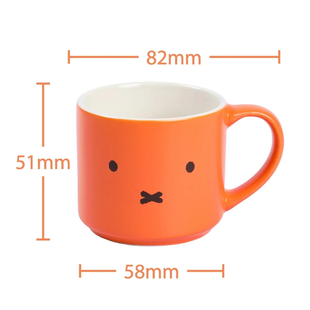 Orange mug with a MIffy face design and measurements on a white background