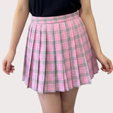 Pink plaid skirt worn by a person on a plain background