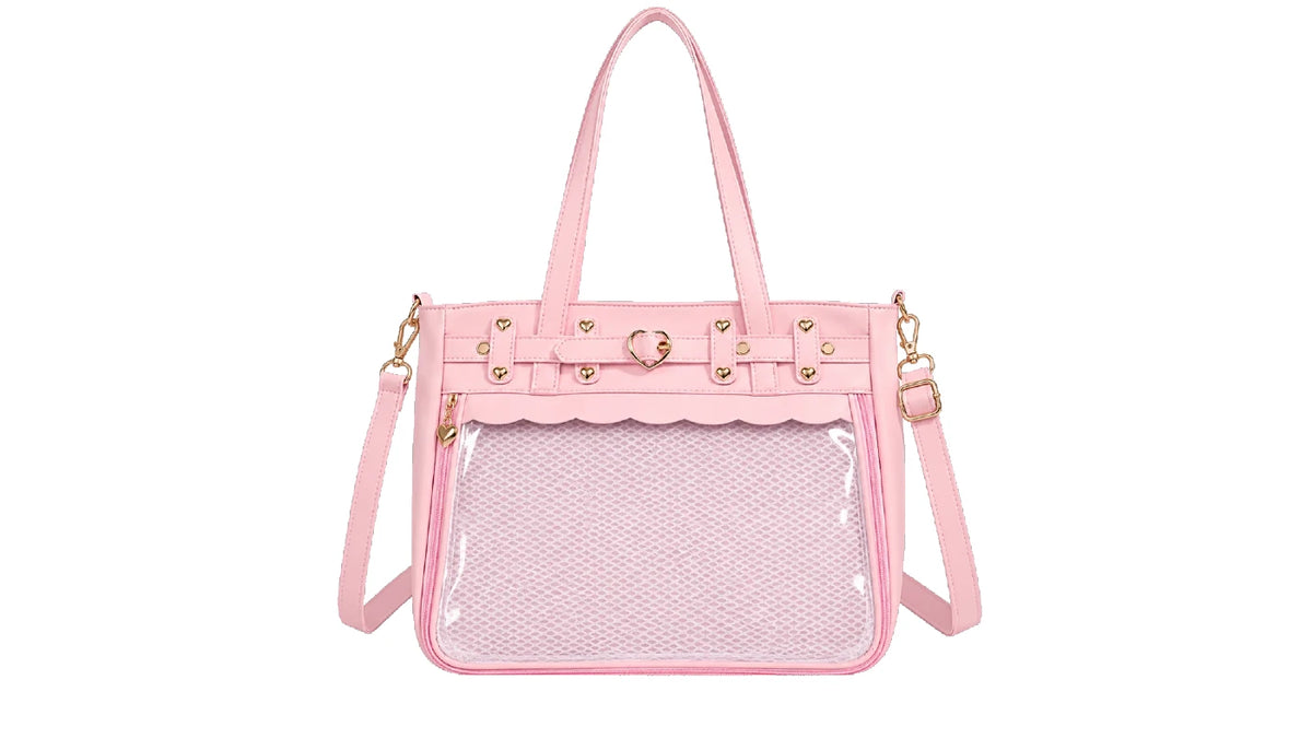 A pink structured ita handbag with a clear front window, scalloped trim, gold-tone hardware, top handles, and a detachable shoulder strap on a plain white background.