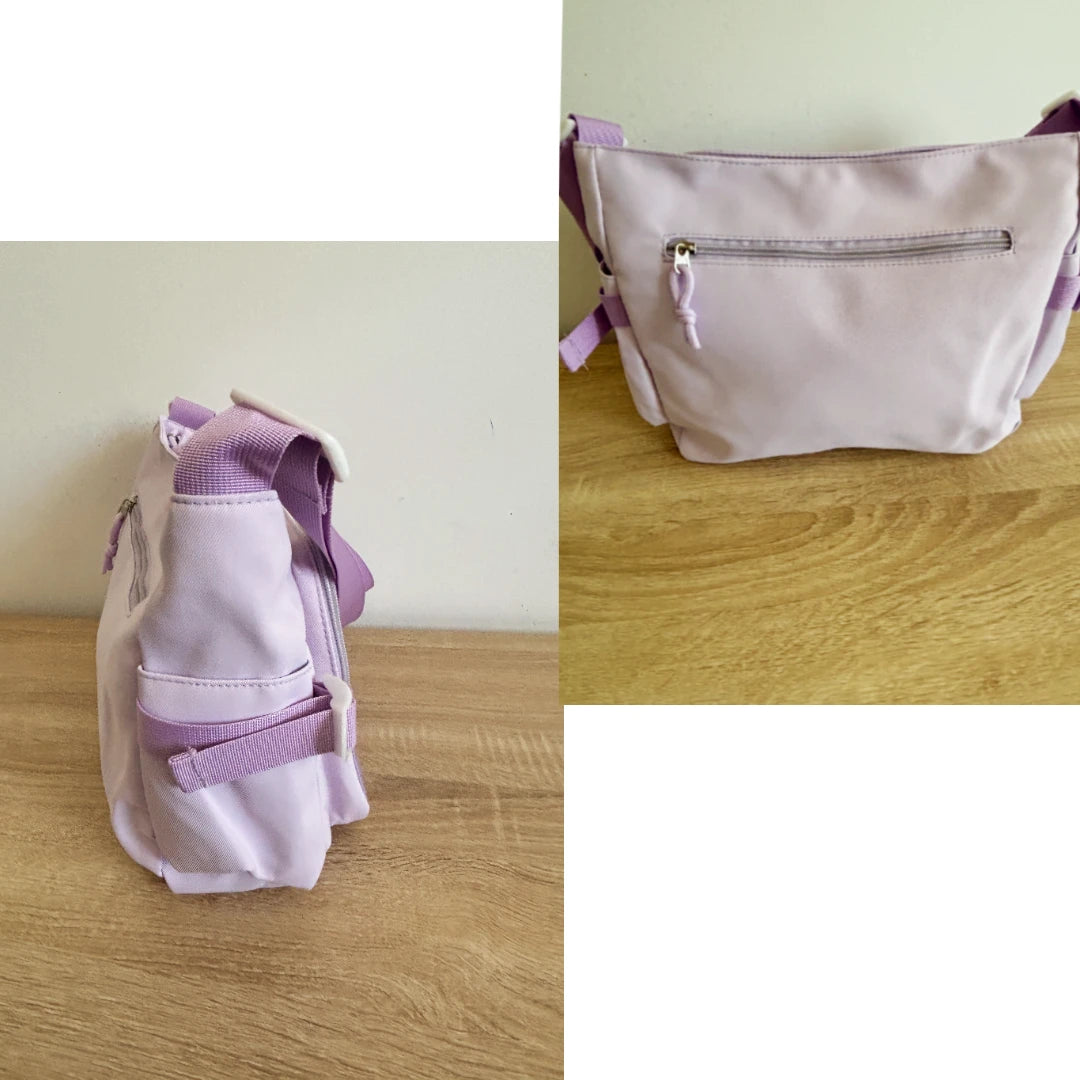 A light purple fabric crossbody ita bag shown from two angles on a wooden tabletop against a plain wall. The right view shows the front with a zippered pocket, and the left view shows the side profile with straps.