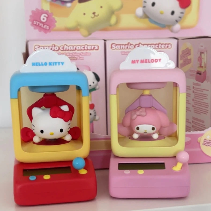 Two small toys featuring Hello Kitty and My Melody in front of their packaging.
