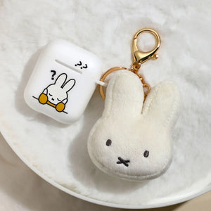 Miffy face plush keychain next to AirPods case showing compact size