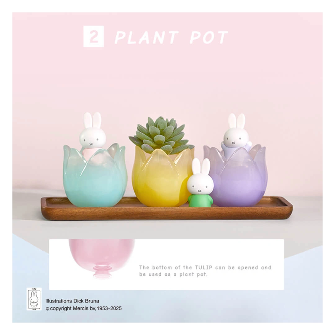 Three colorful rabbit-shaped plant pots on a wooden tray with a pink background.