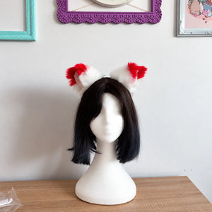 White cat ears with red tips placed on head mannequin 