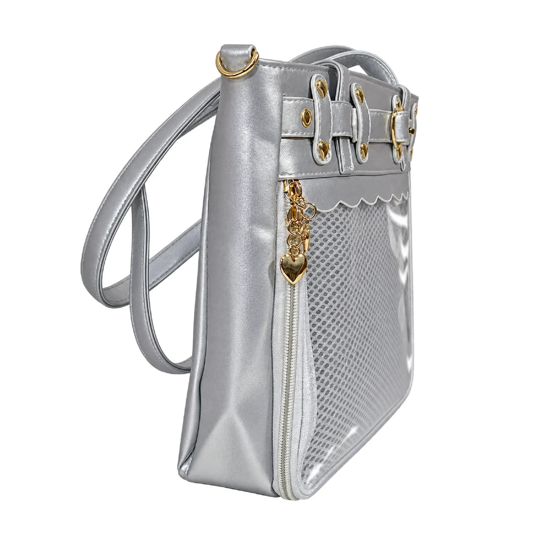 A metallic silver crossbody ita bag with a mesh front pocket, gold-tone hardware, and a clear vinyl side pocket, shown against a plain white background.